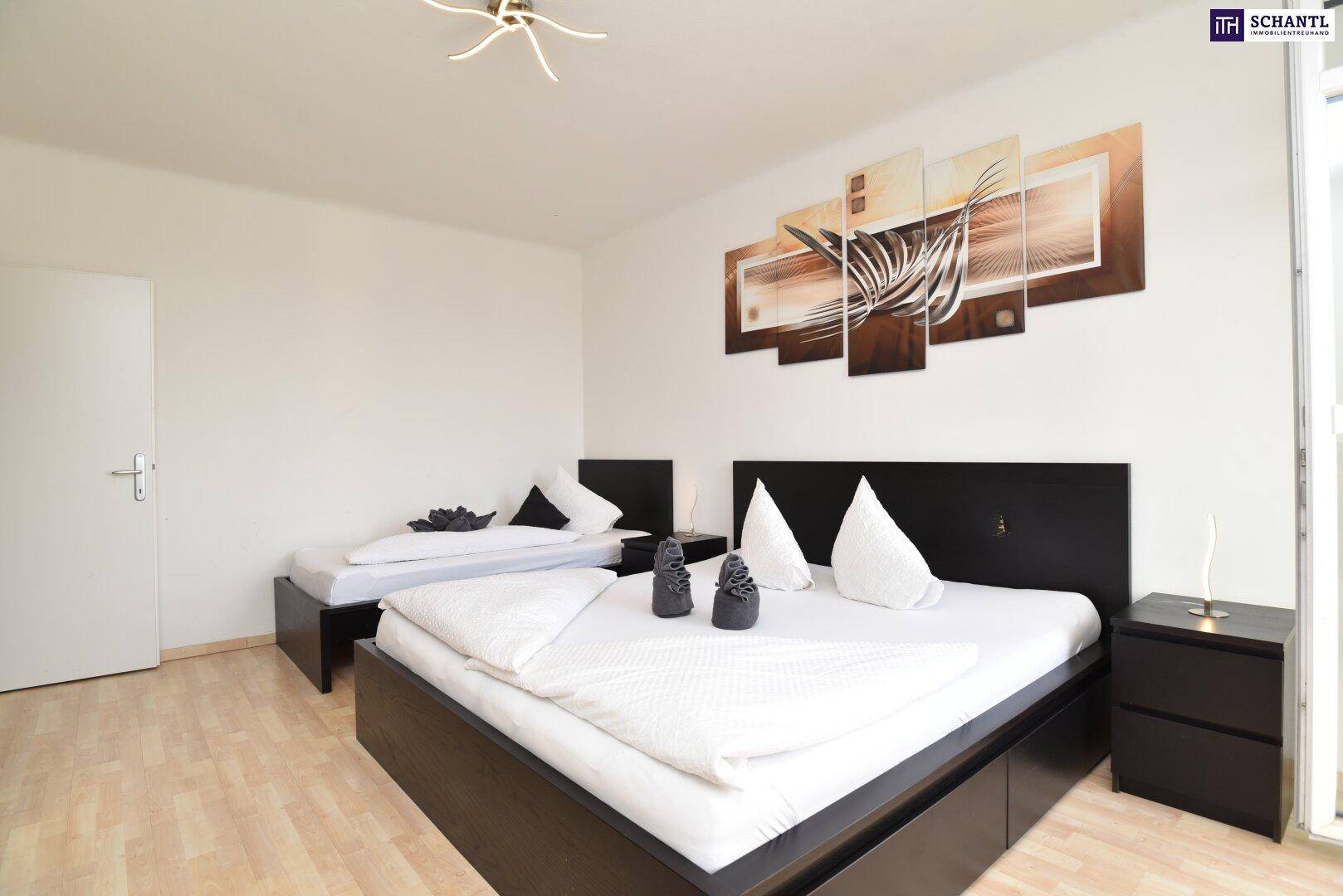 Schlafzimmer mit Doppelbett und Einzelbett, ausgestattet mit dunklen Bettrahmen und hellem Boden.