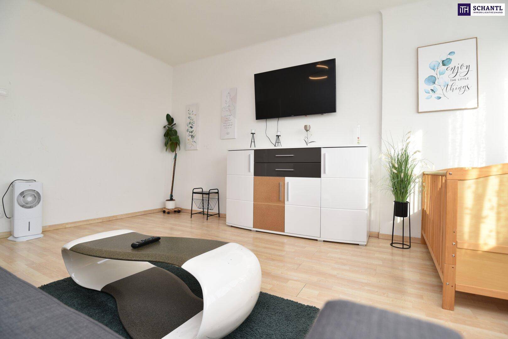Helles Wohnzimmer mit modernem Couchtisch, Fernseher und einem Luftkühler.