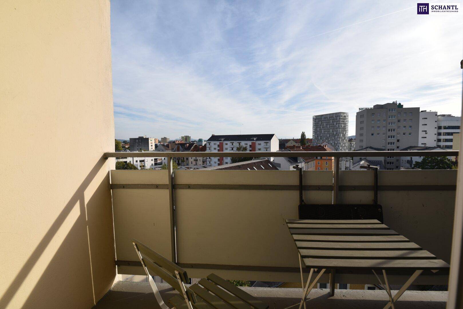 Balkon mit kleinem Tisch und Stühlen, bietet einen weiten Blick über die Stadt.