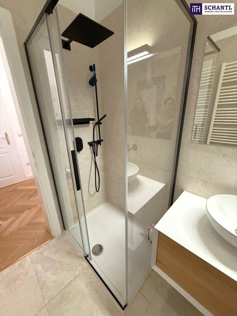 Geräumige begehbare Dusche mit Regenduschkopf und modernen schwarzen Armaturen.
