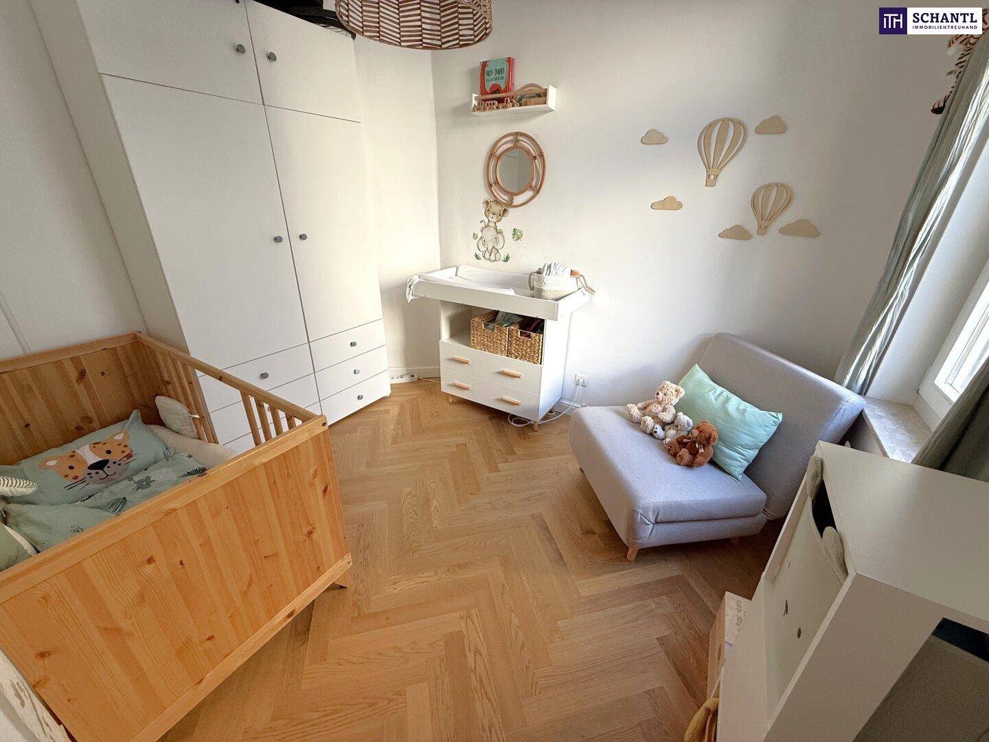 Helles Kinderzimmer mit Babybett, Wickeltisch und Kleiderschrank, ausgestattet mit Fischgrätparkett.