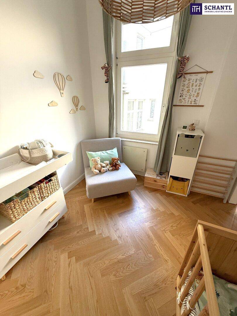 Freundliches Kinderzimmer mit großem Fenster, Babybett und liebevollen Dekorationen.