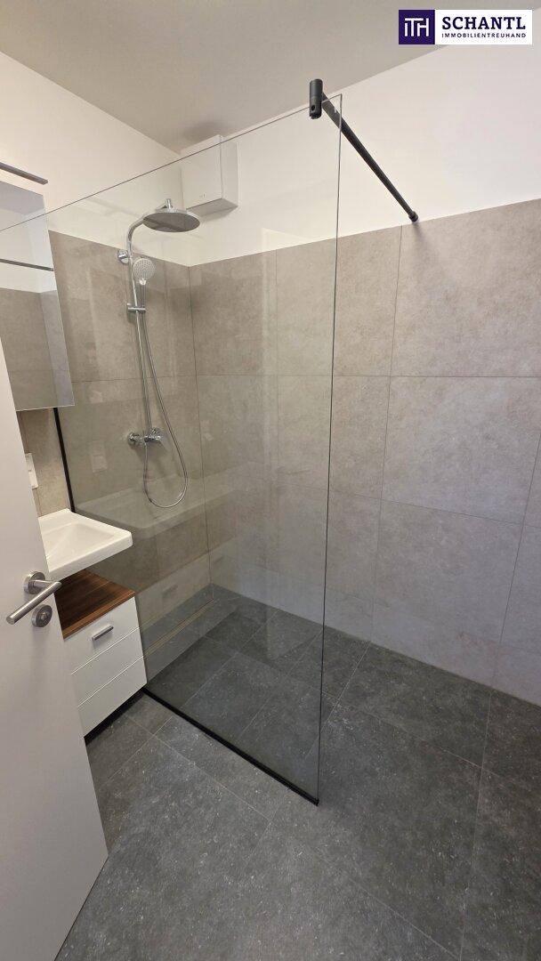 Modernes Badezimmer mit ebenerdiger Dusche, Regenduschkopf und stilvollen grauen Fliesen.