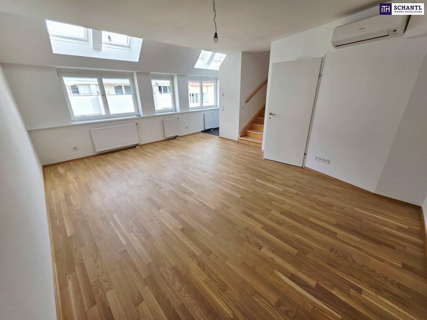 Geräumiger Wohnbereich mit Parkettboden, vielen Fenstern und Dachschrägen, hell und einladend.