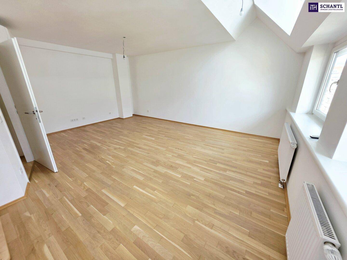 Helles Zimmer mit Parkettboden, weißen Wänden und Dachschrägen, ideal als Schlafzimmer.