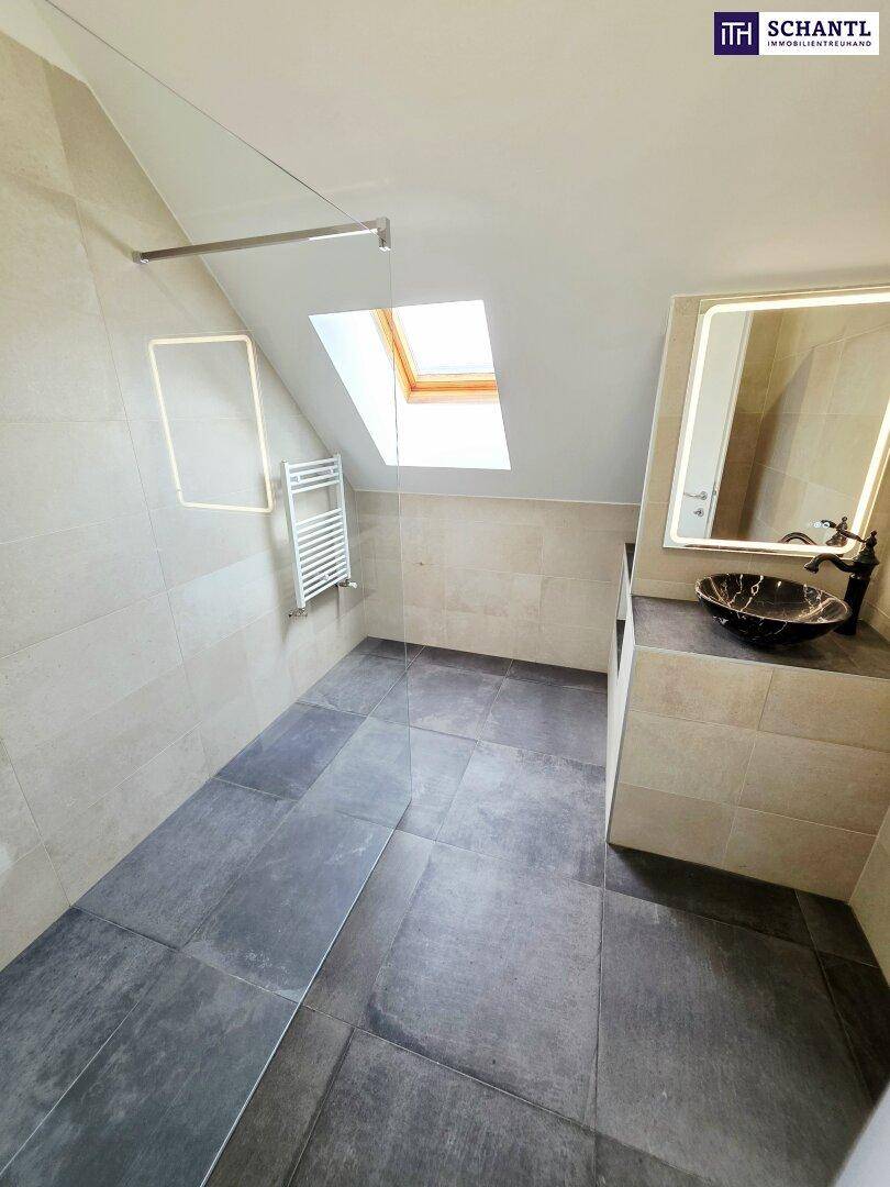 Modernes Badezimmer mit begehbarer Dusche, stilvollem Waschbecken und Dachfenster.