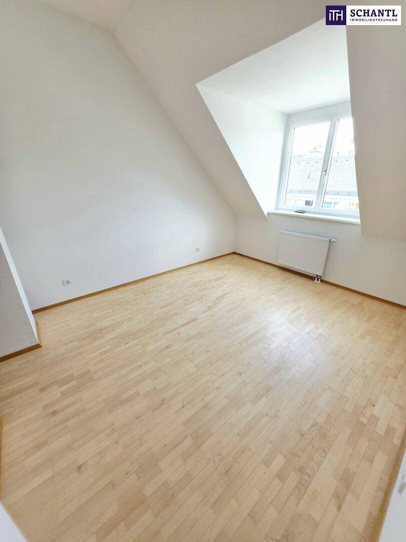 Geräumiges Zimmer mit Parkettboden, weißen Wänden und Dachschrägen, bereit zur Einrichtung.