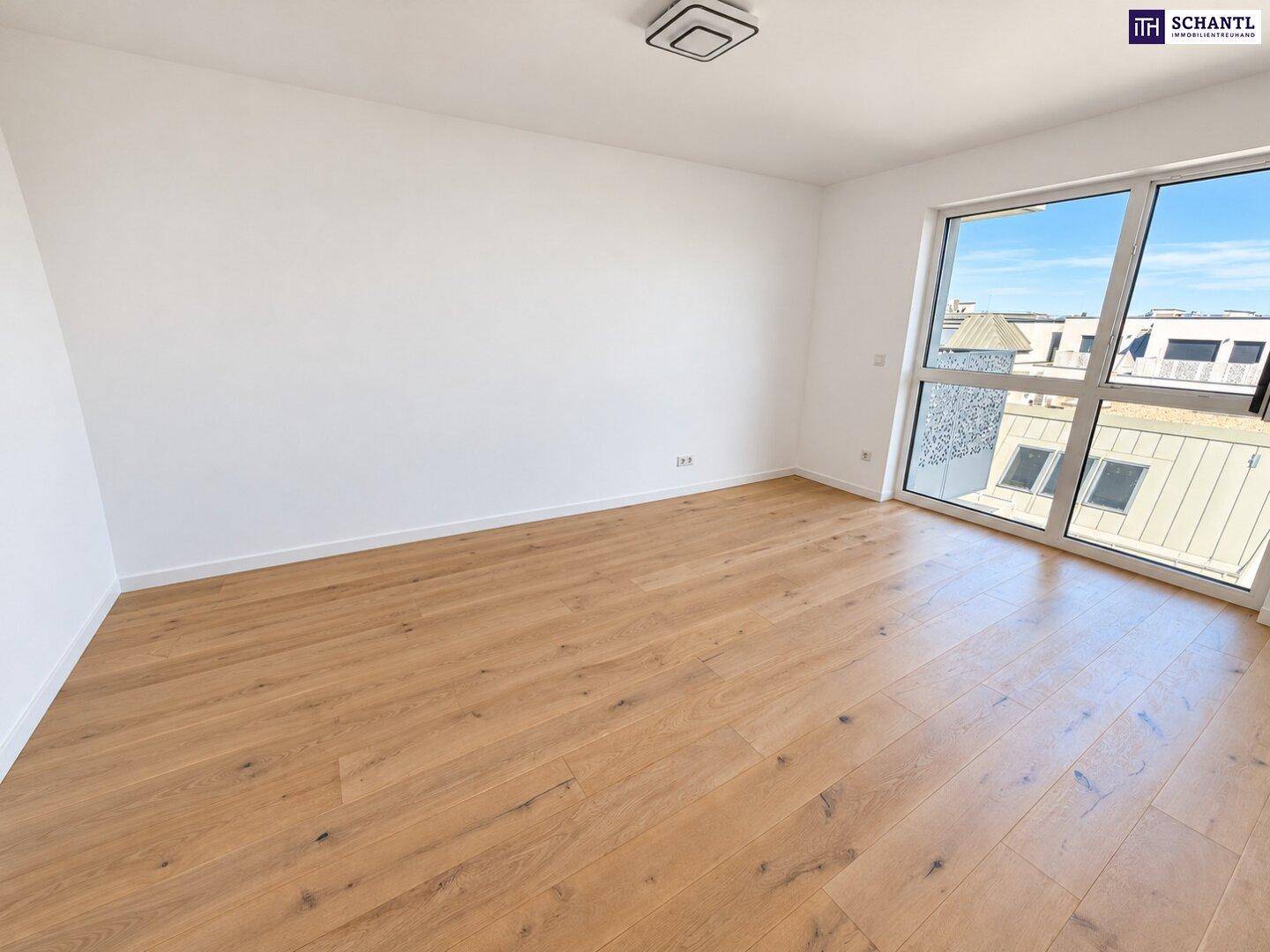 Helles Zimmer mit Holzboden und Blick auf die umliegenden Dächer, bietet viel Privatsphäre.