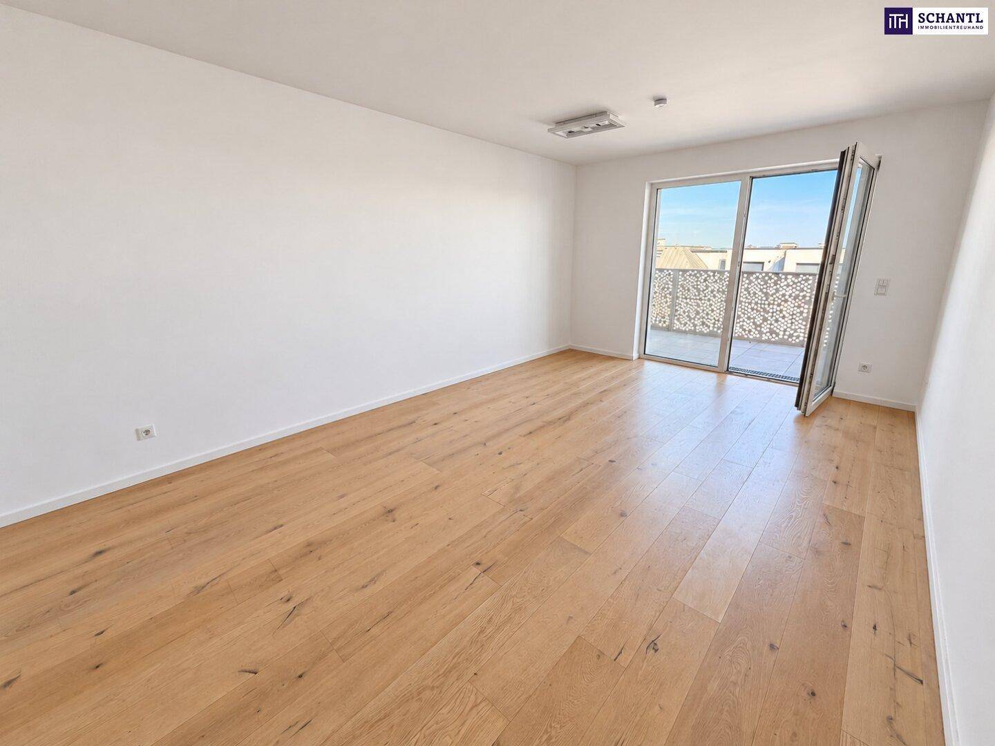 Geräumiges Wohnzimmer mit Holzboden und großem Fenster, das viel Tageslicht hereinlässt.