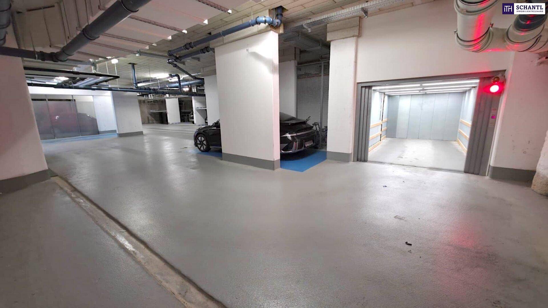 Geräumige Tiefgarage mit offenem Aufzug und weiteren Parkplätzen im Hintergrund.