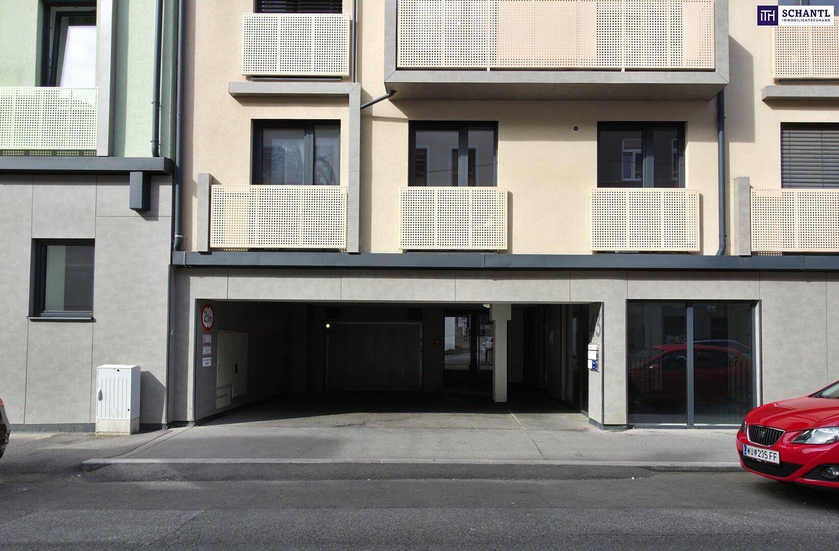 Moderne Gebäudefassade mit Balkonen und ebenerdigem Zugang zur Tiefgarage.