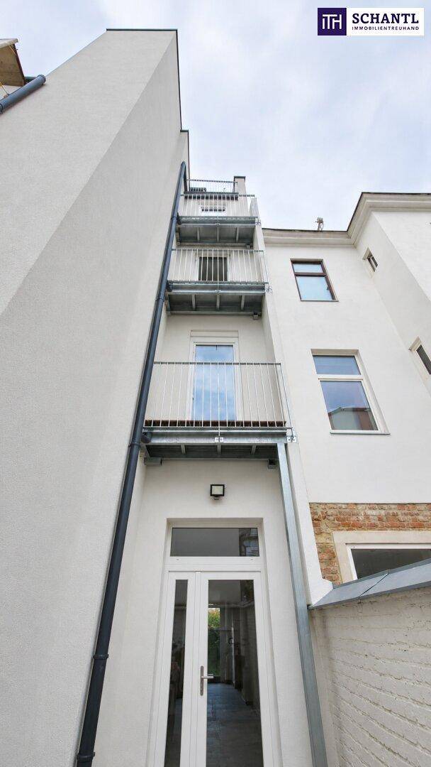 Vertikal gestapelte Balkone an der Seitenfassade eines Gebäudes mit weißem Anstrich.