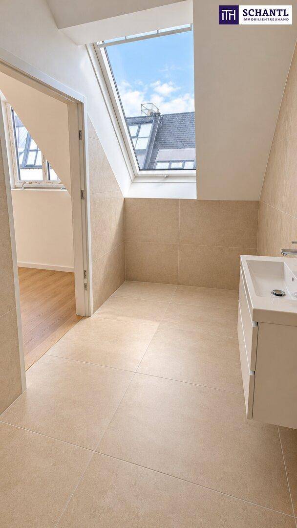Modernes Badezimmer mit Dachfenster, beigefarbenen Fliesen und schwebendem Waschbecken.