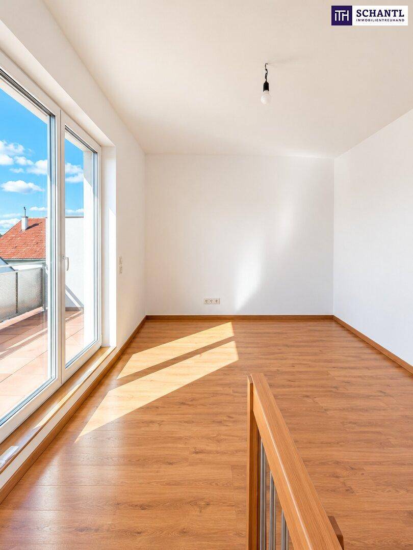 Lichtdurchfluteter Raum mit Laminatboden und großem Fenster mit Blick auf den Balkon.