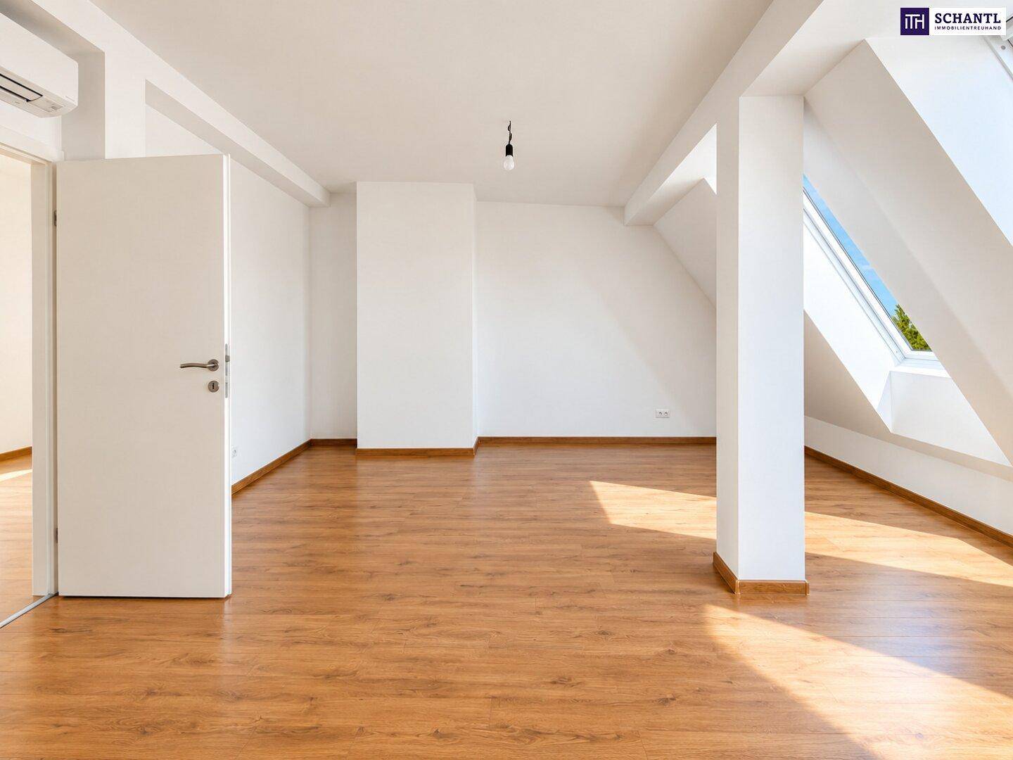 Dachgeschosszimmer mit Laminatboden, Dachschrägen und einem Dachfenster für natürliches Licht.