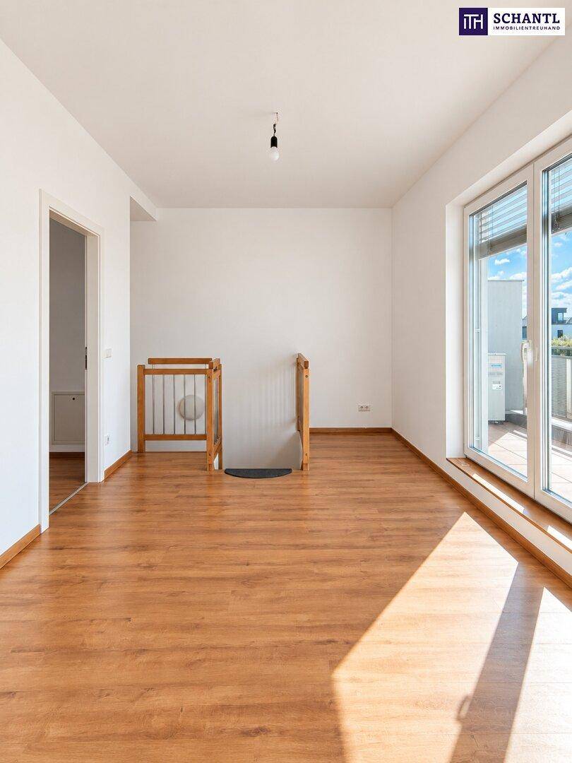 Heller Raum mit Laminatboden und Zugang zu einem Balkon, ideal als Wohn- oder Schlafzimmer.