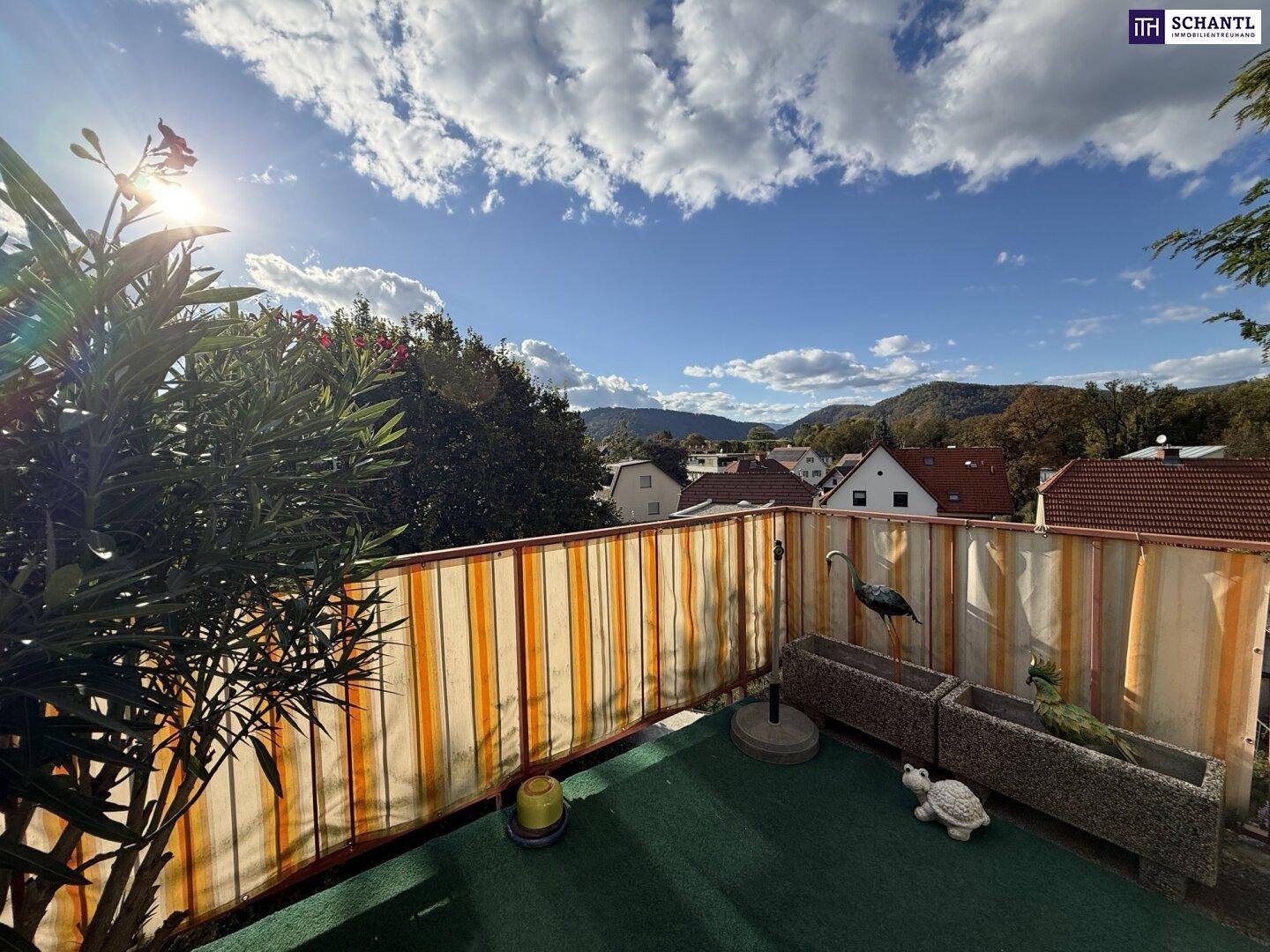 Gemütlicher Balkon mit Kunstrasen, Sichtschutz und schöner Aussicht auf die umliegende Landschaft.