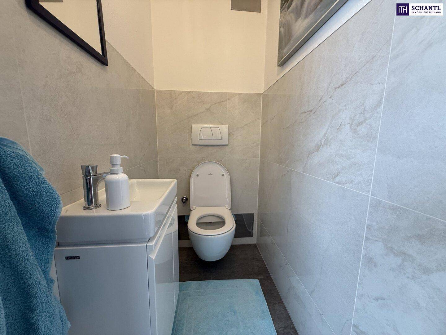 Modernes Gäste-WC mit wandhängender Toilette, kleinem Waschbecken und hellen Fliesen.
