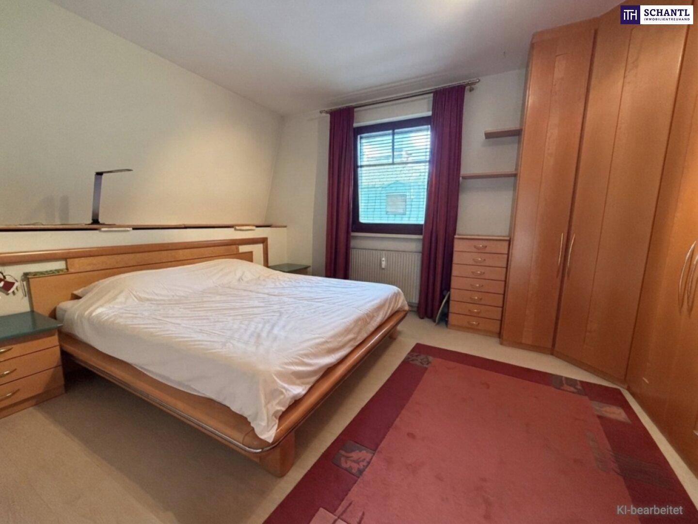 Geräumiges Schlafzimmer mit großem Doppelbett, Holzmöbeln und einem Fenster mit dunklen Vorhängen.