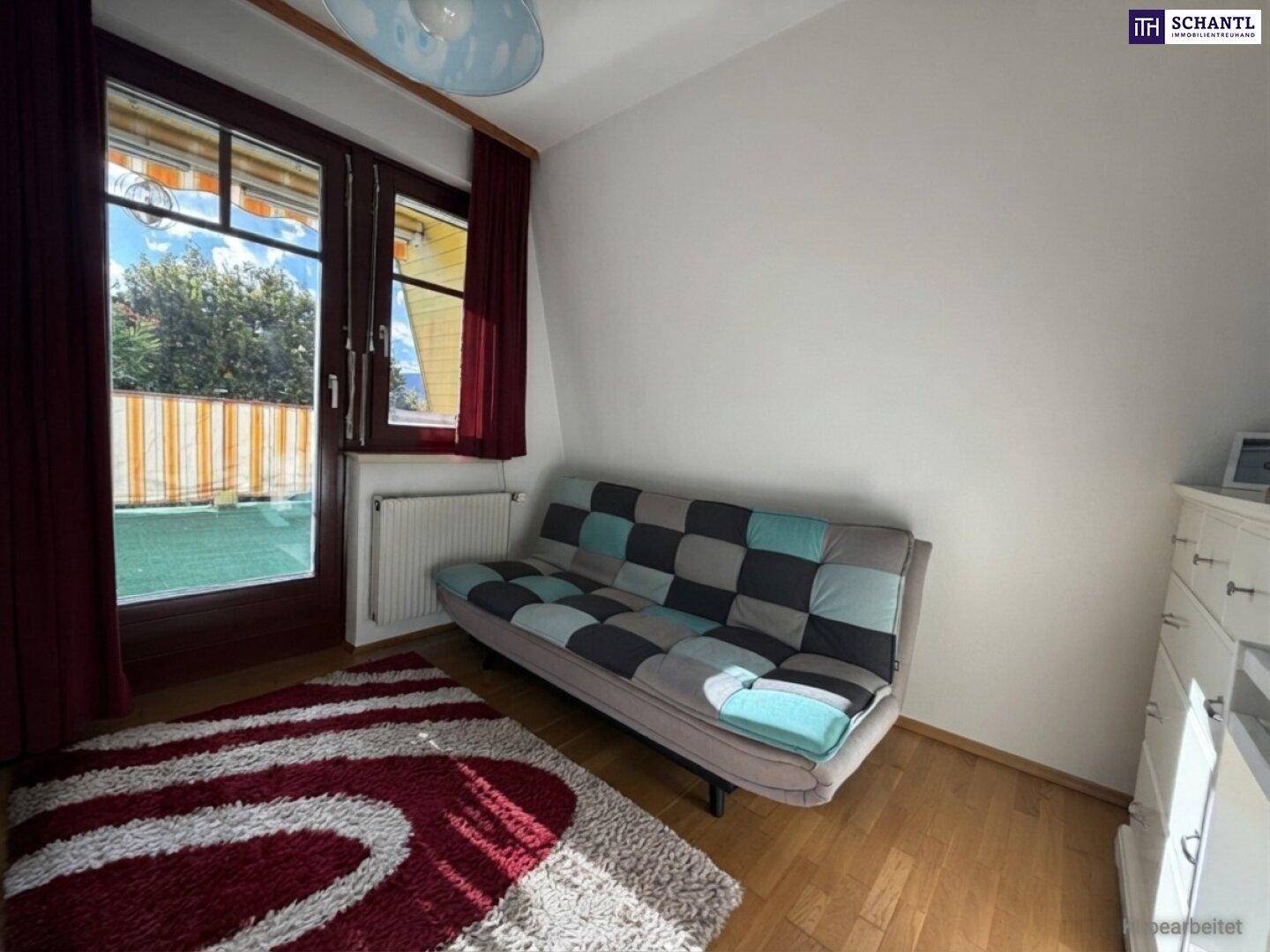 Zimmer mit Schlafsofa, Holzboden und Zugang zu einem Außenbereich, ideal als Gästezimmer.
