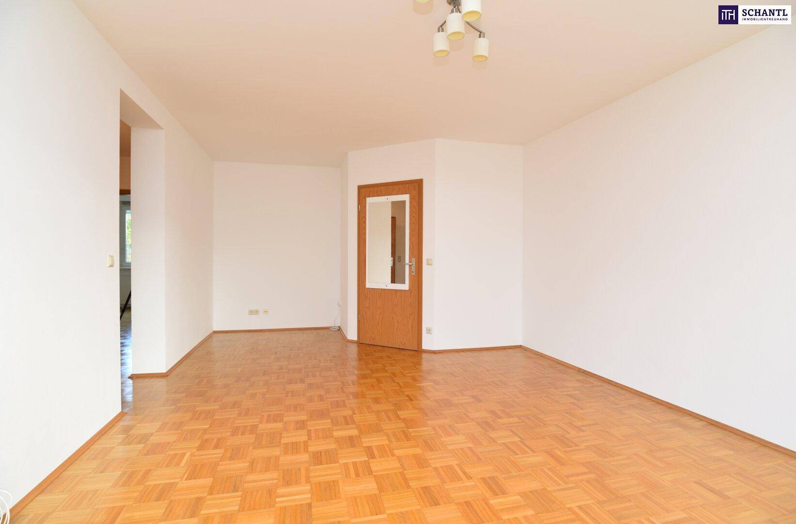 Geräumiges Wohnzimmer mit Parkettboden und hellem Ambiente, bereit zur individuellen Gestaltung.