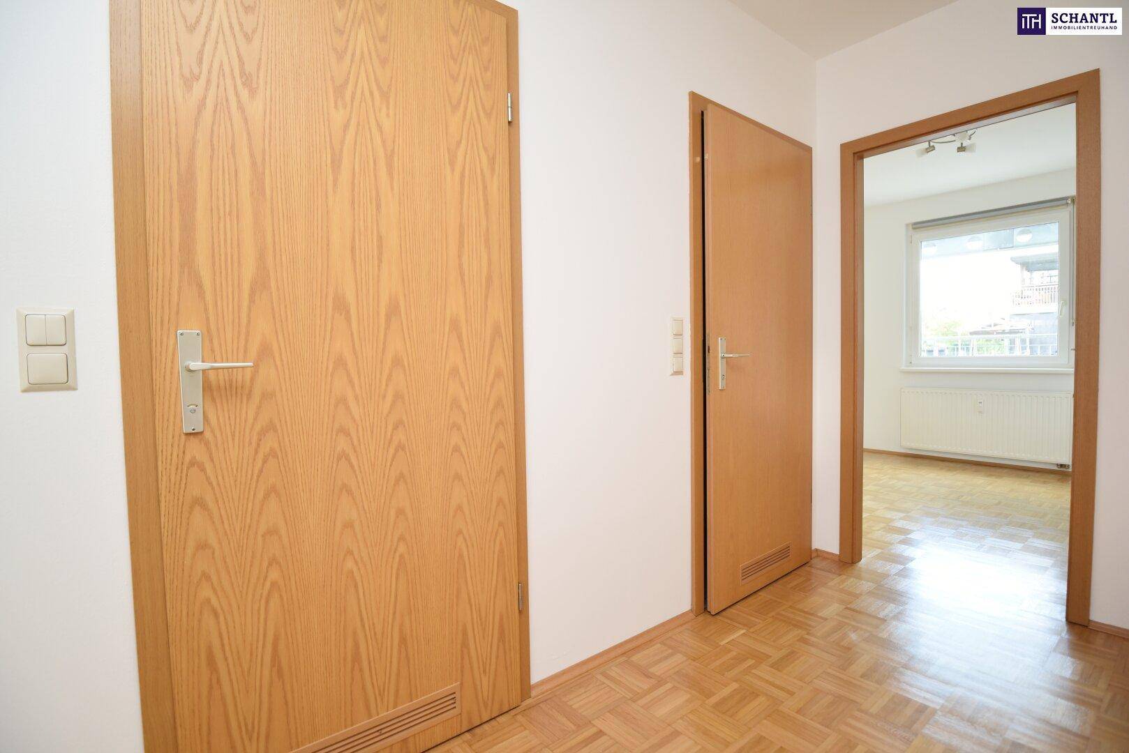 Heller Flur mit Holztüren, der zu den verschiedenen Räumen der Wohnung führt.