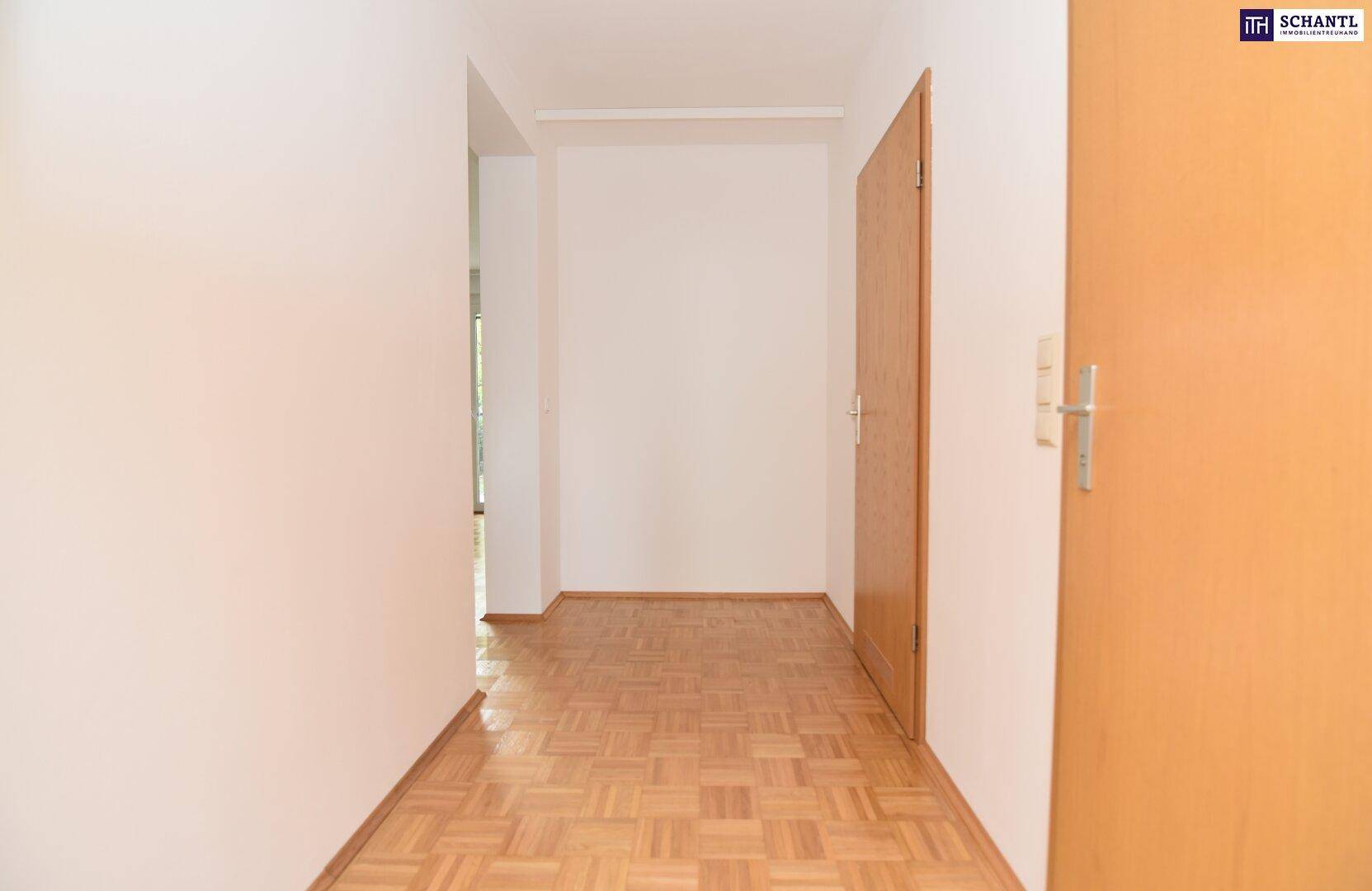 Heller Flur mit Parkettboden, der zu den verschiedenen Räumen der Wohnung führt.
