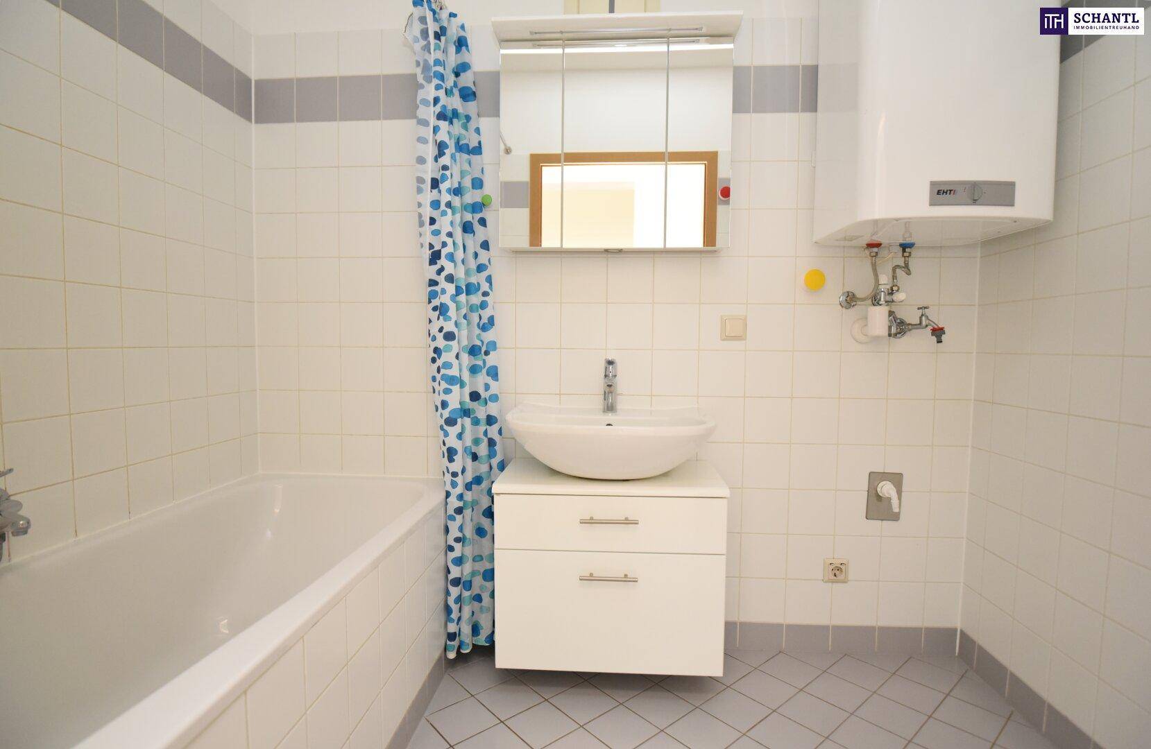 Gefliestes Badezimmer mit Badewanne, Aufsatzwaschbecken und Warmwasserboiler.