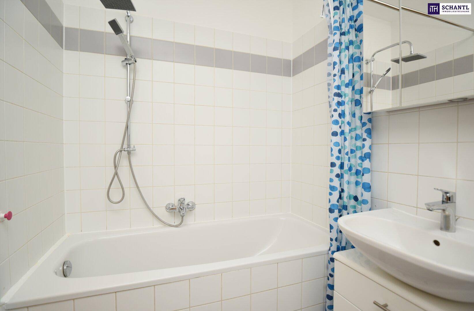 Gefliestes Badezimmer mit Badewanne, Duschvorhang und Einzelwaschbecken.