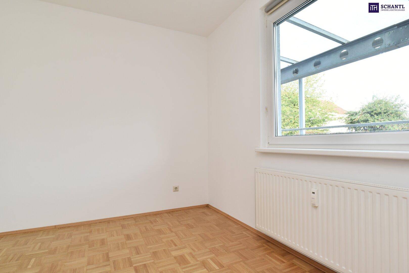Helles Schlafzimmer mit Parkettboden und großem Fenster, das viel Tageslicht bietet.