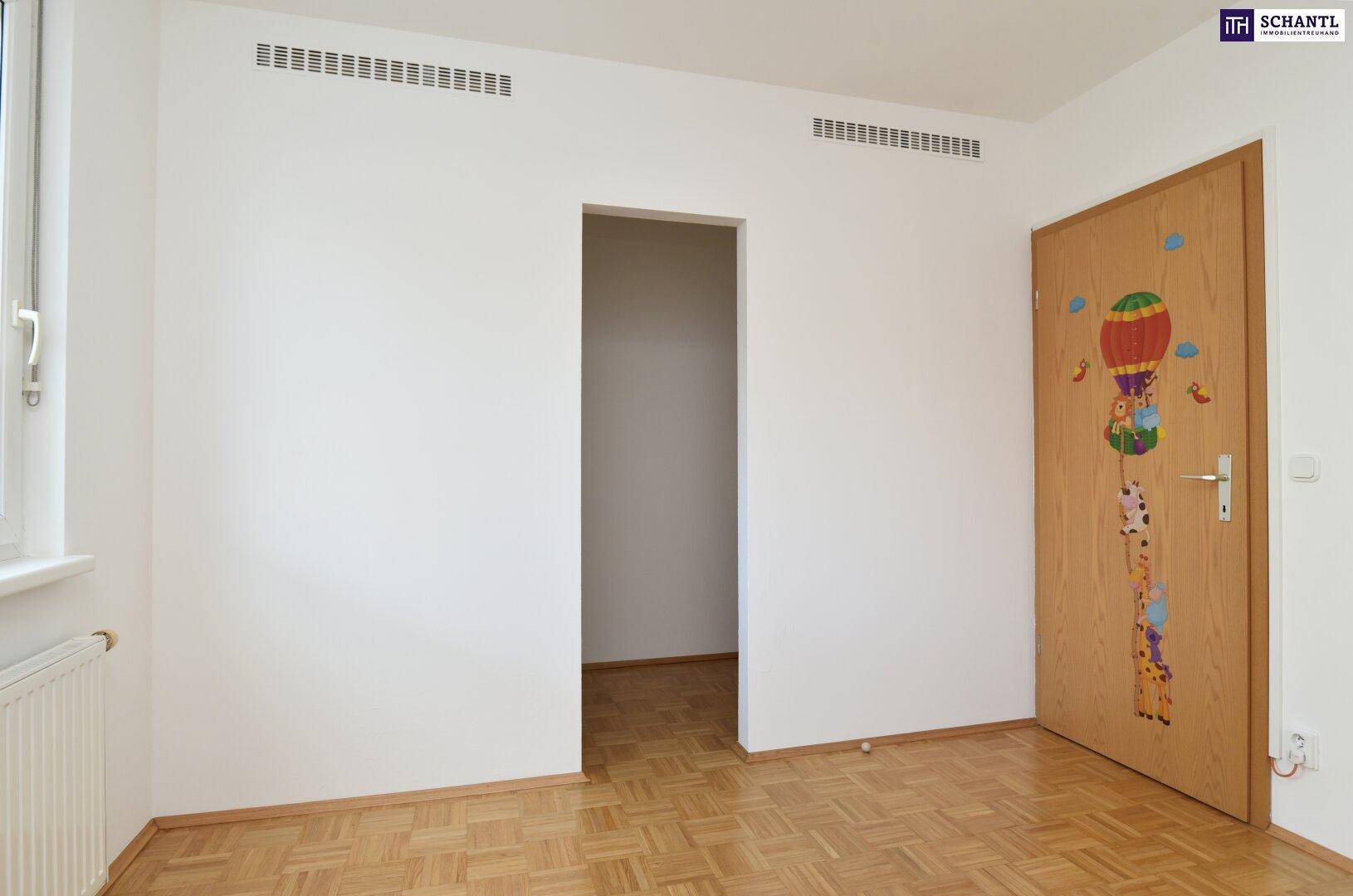 Kinderzimmer mit Parkettboden und einer verspielten Türdekoration.