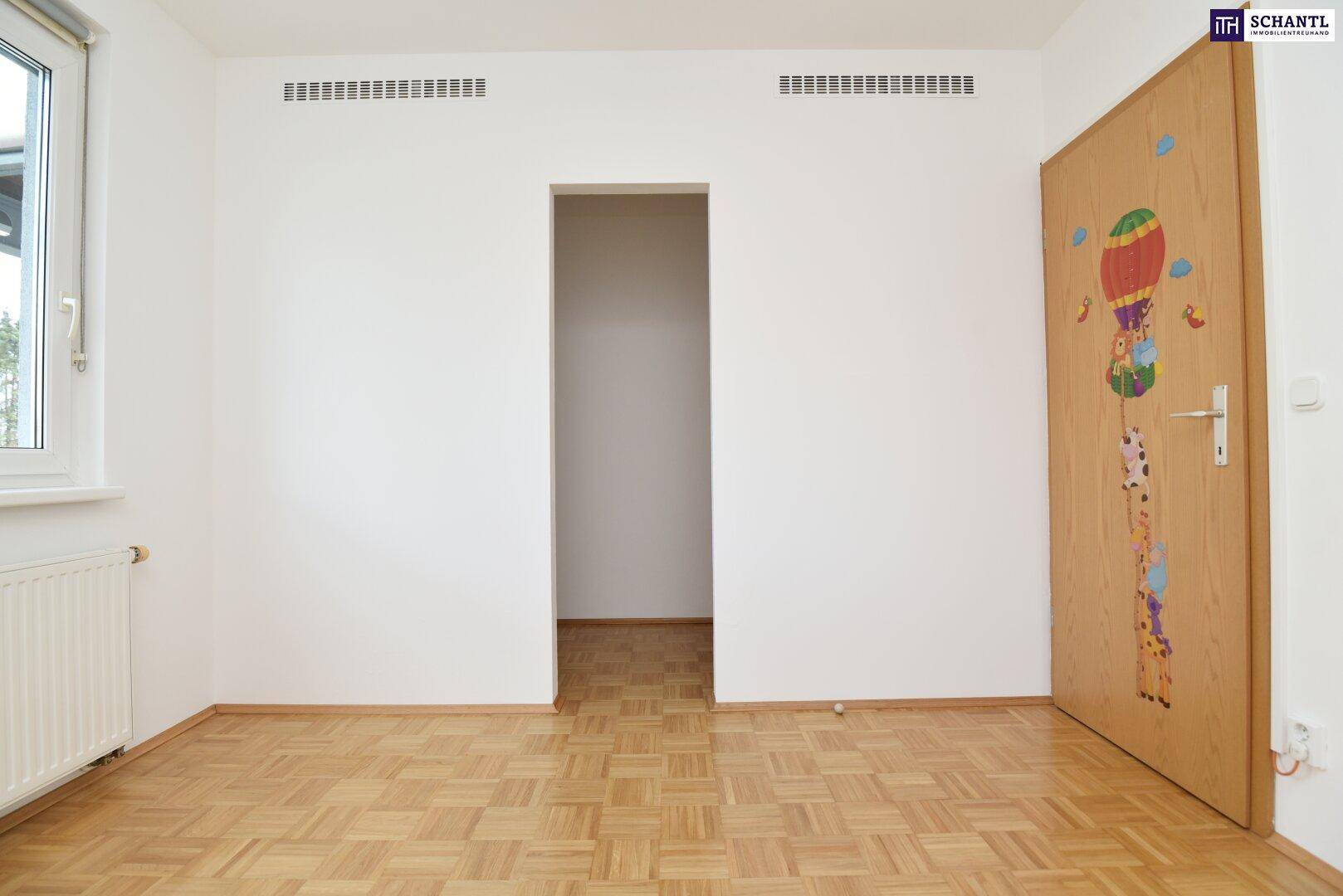 Kinderzimmer mit Parkettboden und einer verspielten Türdekoration.