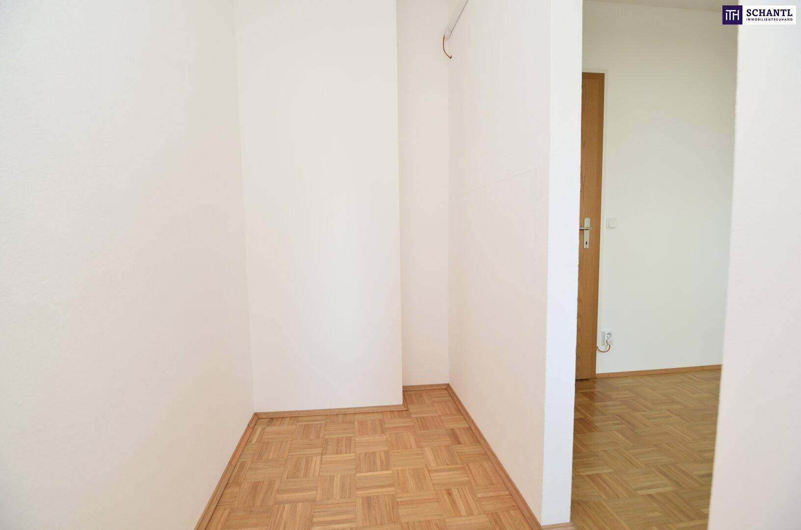 Heller Flur mit Parkettboden und weißen Wänden, bereit zur individuellen Gestaltung.