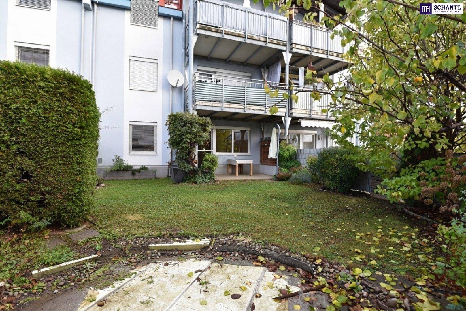 Gartenbereich mit Rasenfläche und Blick auf das Gebäude mit mehreren Balkonen.