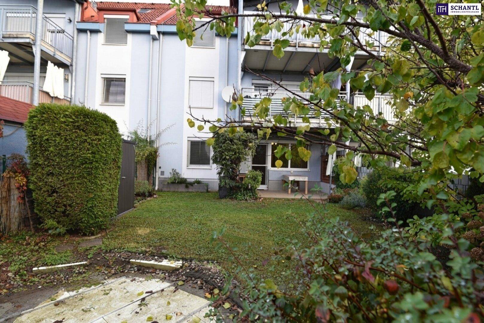 Garten mit Rasen und Blick auf die Rückseite des Wohngebäudes mit Balkonen.