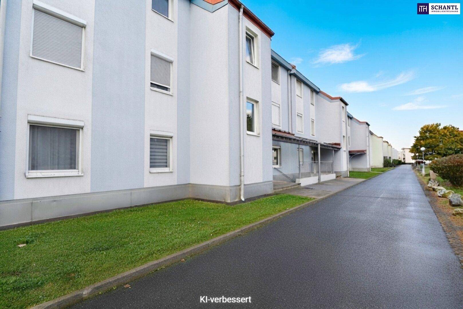 Reihe von Wohngebäuden entlang einer Straße mit gepflegten Grünflächen.