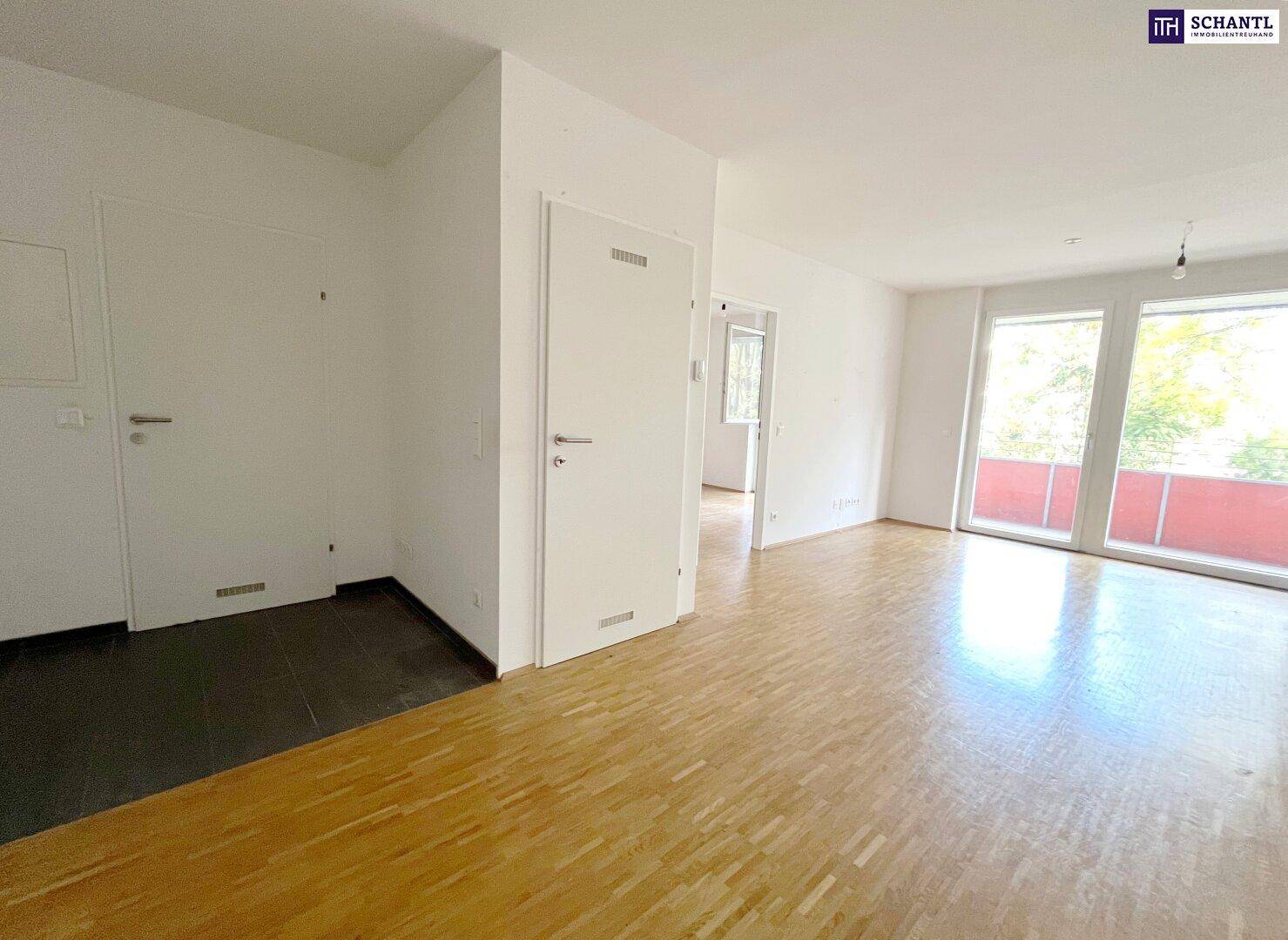 Geräumiger Wohnbereich mit Parkettboden und Zugang zum Balkon, der viel Licht spendet.