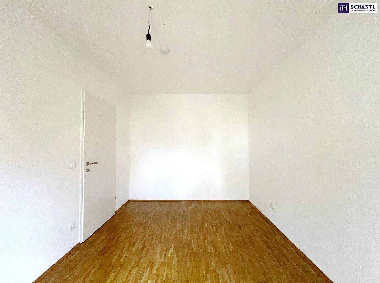 Helles Schlafzimmer mit Parkettboden und weißen Wänden, bereit für individuelle Gestaltung.
