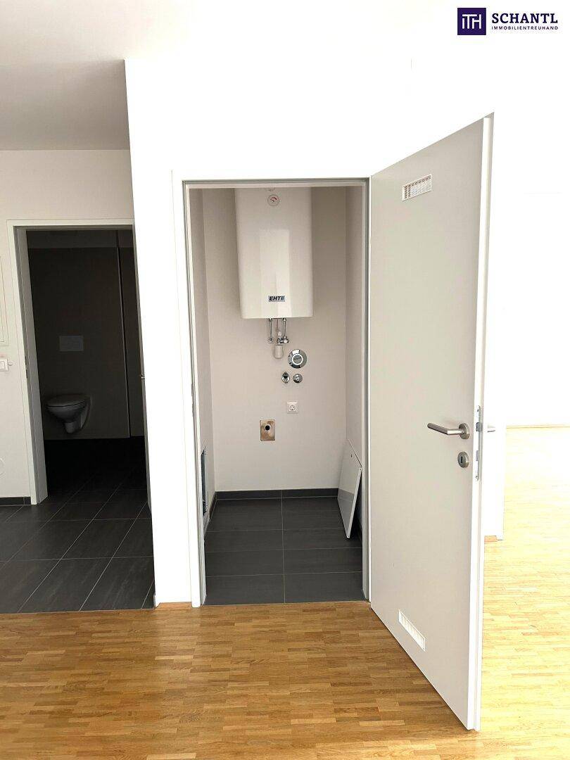 Abstellraum mit Warmwasserboiler und Anschlüssen, neben einem Badezimmer oder WC gelegen.