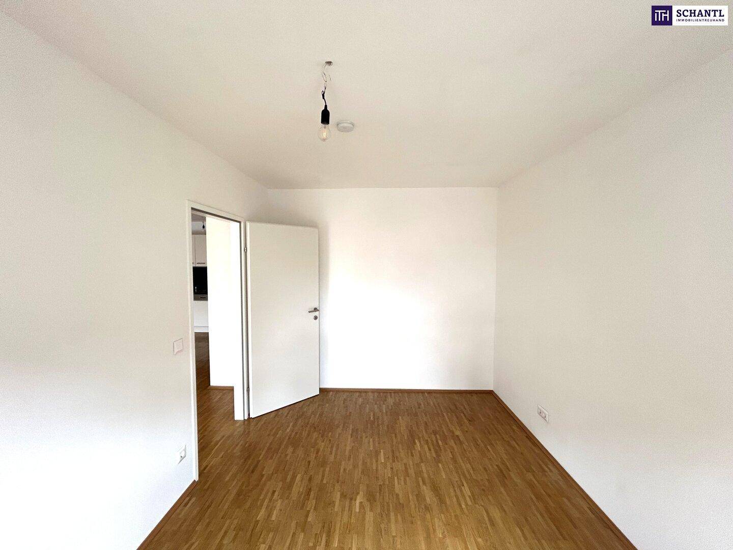 Leerer Raum mit Parkettboden und weiß gestrichenen Wänden, bereit zur individuellen Gestaltung.