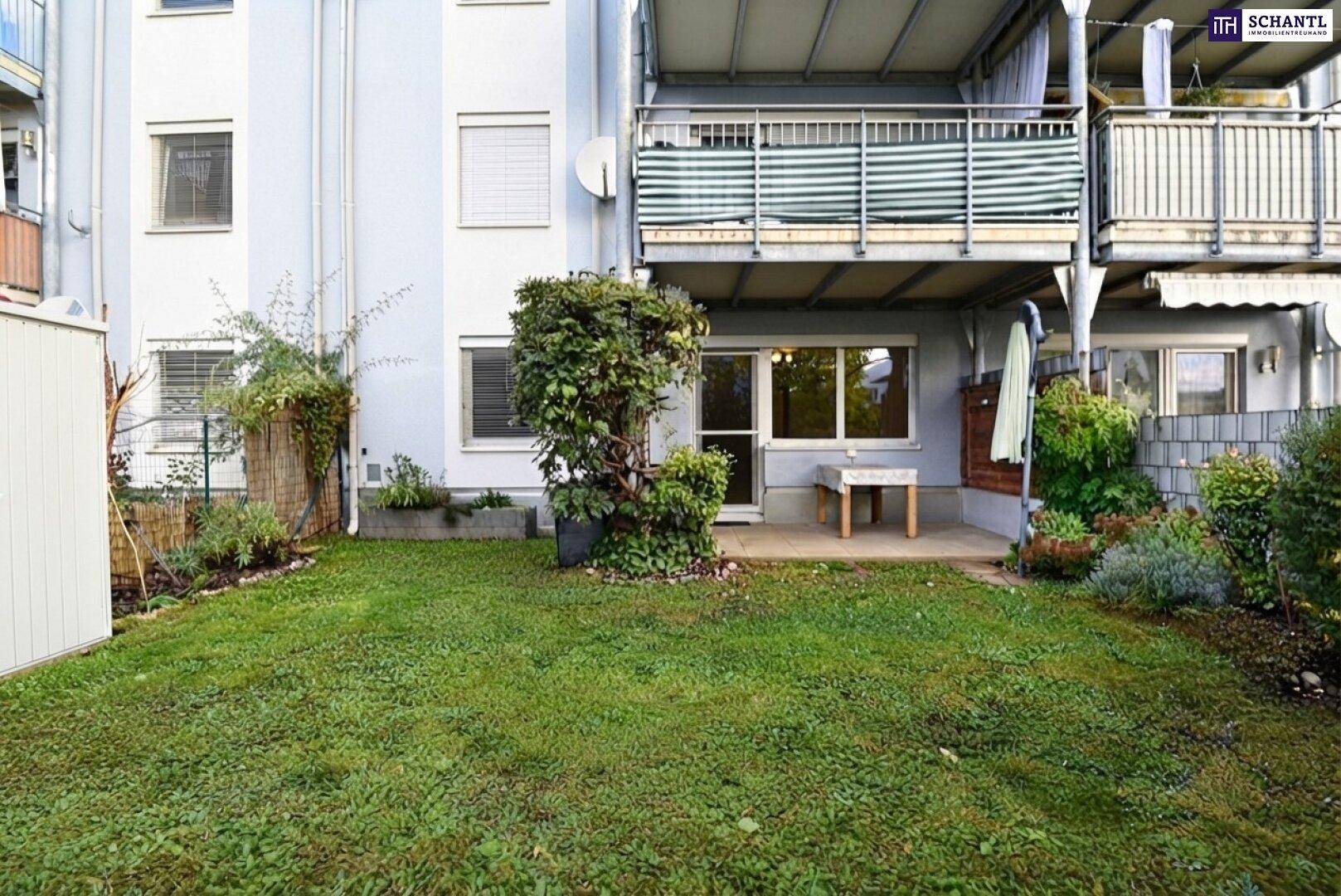 Grüner Garten mit kleiner Terrasse und Zugang zum Gebäude mit Balkonen.