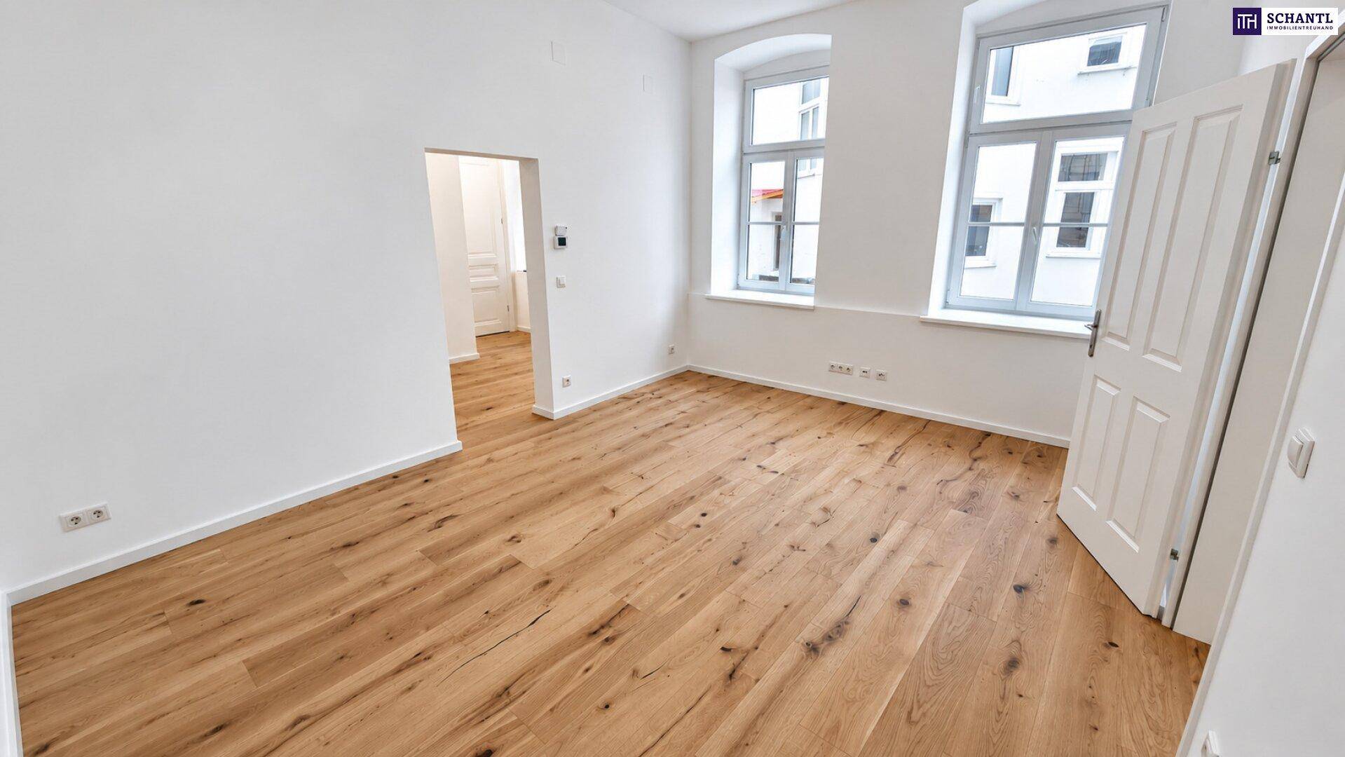 Geräumiges Zimmer mit Holzboden und zwei hohen Fenstern, frisch renoviert.
