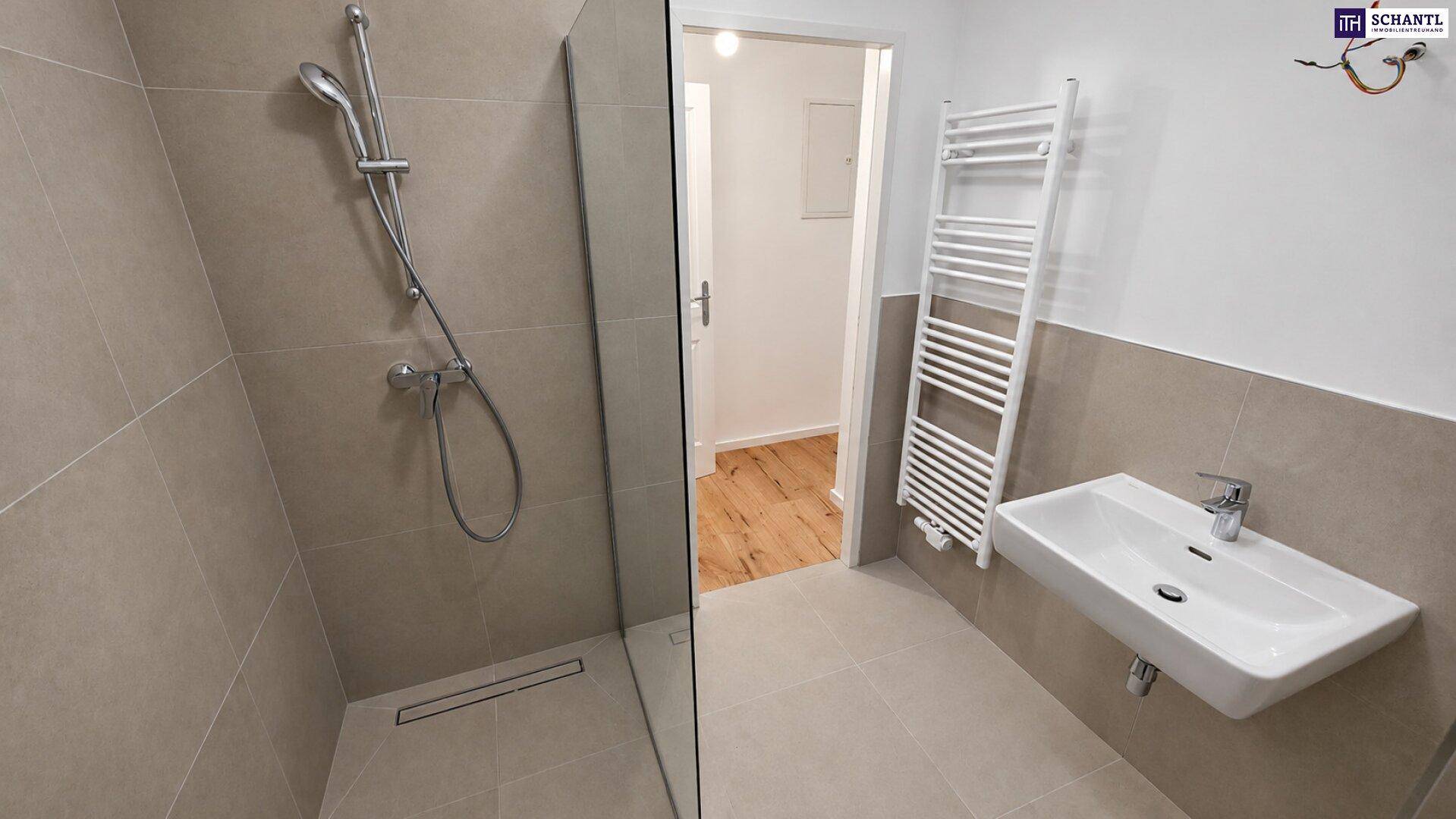 Modernes Badezimmer mit ebenerdiger Dusche, Waschbecken und beheiztem Handtuchhalter.