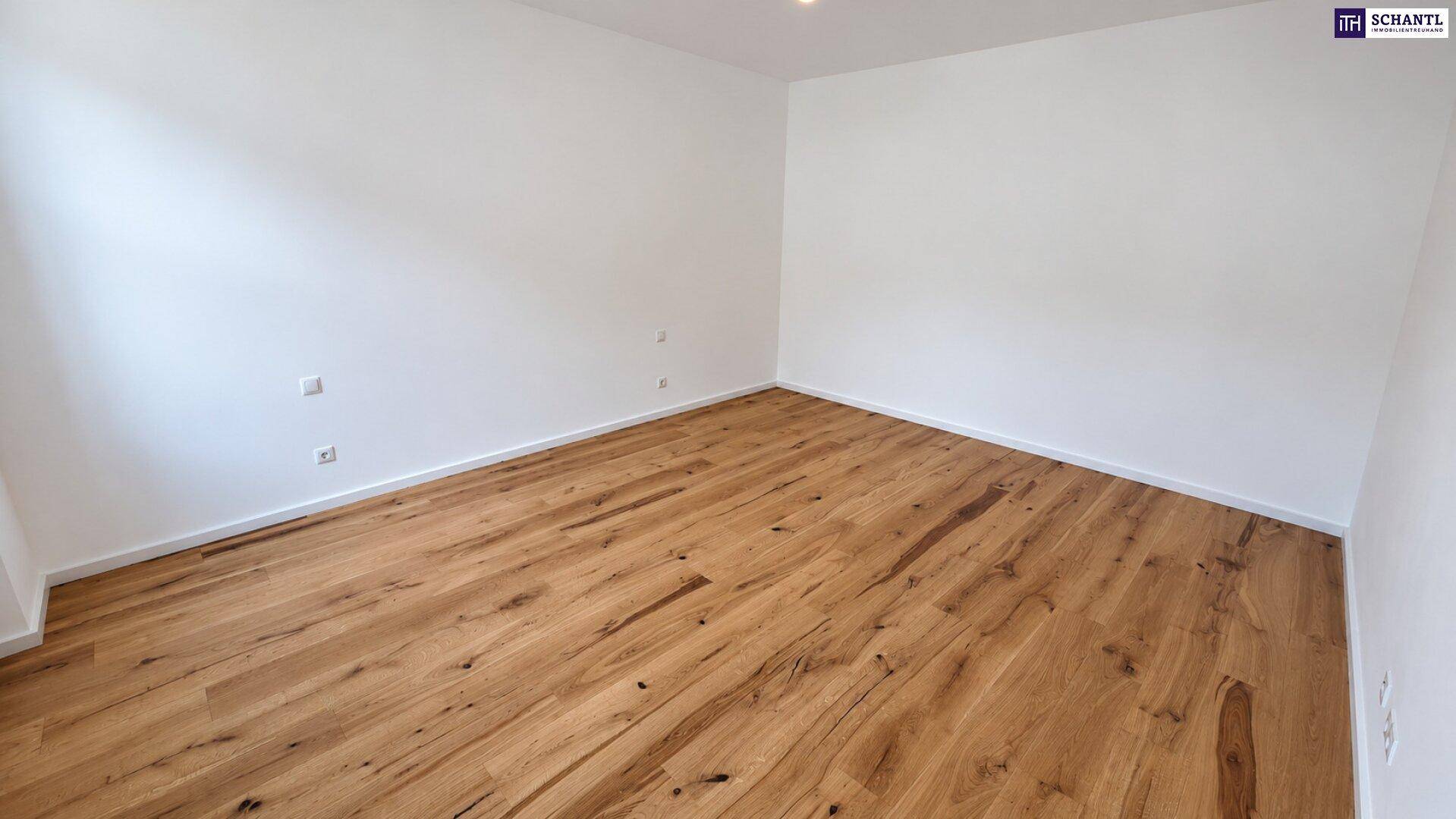 Leeres Zimmer mit neuem Holzboden und weißen Wänden, bereit für neue Einrichtungsideen.
