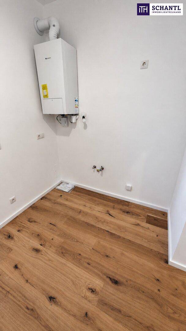Detailansicht der Heizungsanlage in einem praktischen Hauswirtschaftsraum mit Holzboden.