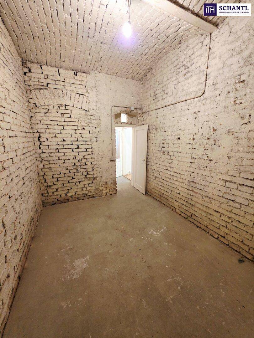Geräumiger Kellerraum mit Ziegelgewölbedecke, Betonboden und einem Durchgang zu einem weiteren Bereich.