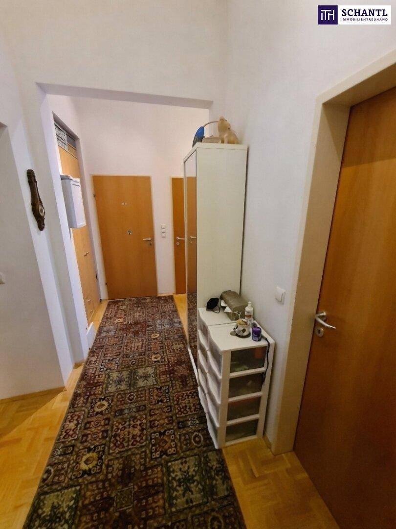 Langer Flur mit Parkettboden, Teppichläufer und mehreren Türen zu den angrenzenden Räumen.