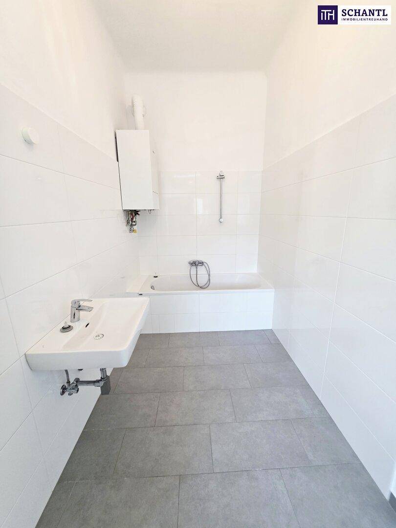 Modernes Badezimmer mit weißen Fliesen, Badewanne und Waschbecken.