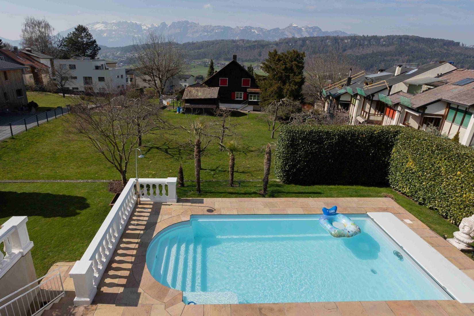 Sonniger Poolbereich mit weitem Blick auf die umliegende Landschaft und Berge.