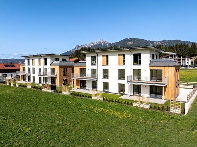 Neubau-Apartments mit zeitgenössischer Architektur, Balkonen und Blick auf die grüne Landschaft.